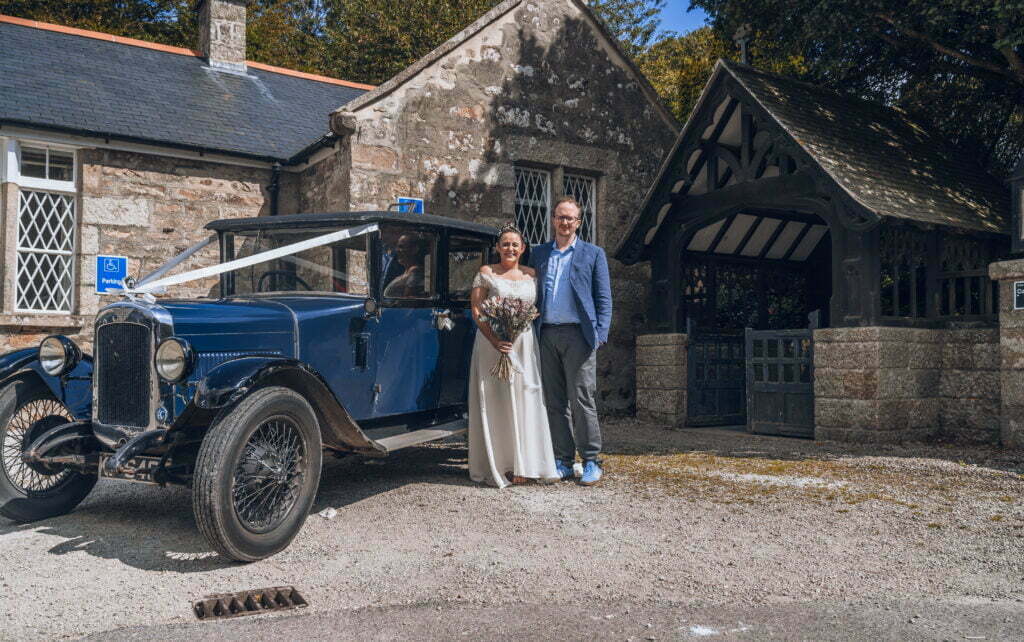 Nick and Tanya standing next to their wedding car