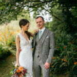 Damien looking at the camera while Marcella is looking towards him